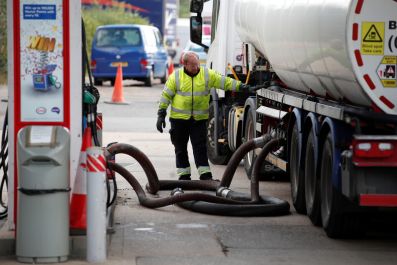 Delivery driver refills pumps at petrol station amid fuel shortage in Flamstead, St Albans