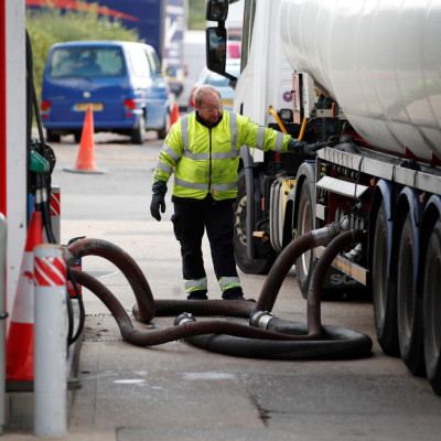 Delivery driver refills pumps at petrol station amid fuel shortage in Flamstead, St Albans