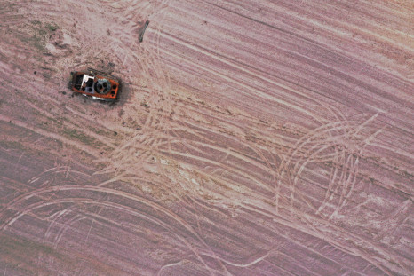 A military vehicle is pictured in a grain field previously mined with explosives in Chernihiv region