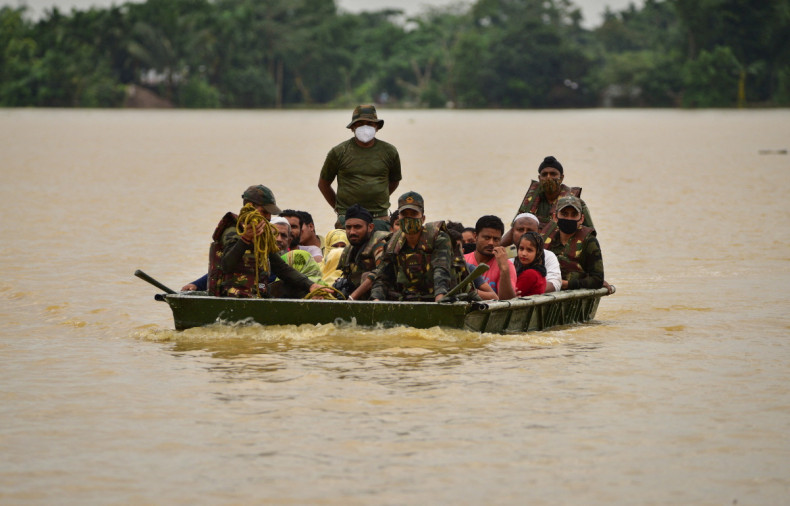 Indian Army soldiers evacuate people from flooded area to a safer place after heavy rains at a village in Hojai district