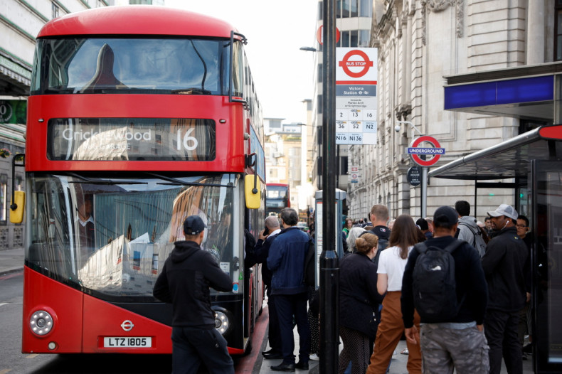 Passengers board a bus outside Victoria Station, in London