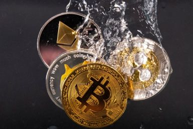 Souvenir tokens representing cryptocurrency networks Bitcoin, Ethereum, Dogecoin and Ripple plunge into water