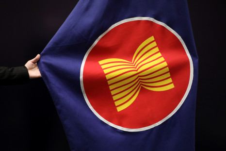 A worker adjusts an ASEAN flag at a meeting hall in Kuala Lumpur