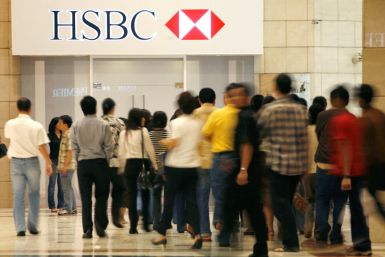 People walk in front of the headquarters for HSBC Bank in Jakarta