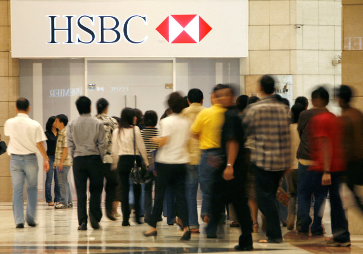 People walk in front of the headquarters for HSBC Bank in Jakarta