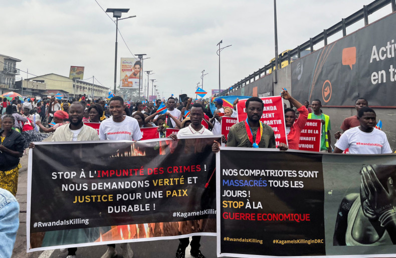 Civil society members hold banners during an anti-Rwanda protest amid tensions between Kinshasa and Kigali over Rwanda's suspected backing of the M23 rebel group, in Kinshasa,