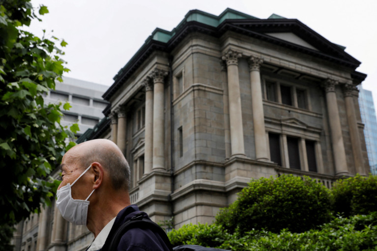 A man wearing a protective mask stands in front of the headquarters of Bank of Japan amid the coronavirus disease (COVID-19) outbreak in Tokyo