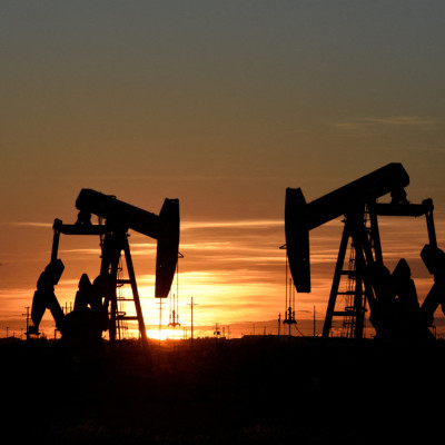 Pump jacks operate at sunset in an oil field in Midland