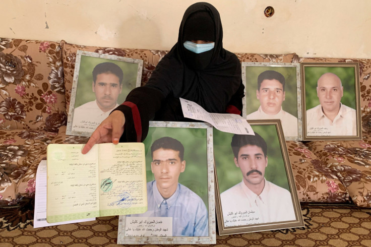 A woman shows the death certificate of one of her brothers killed by the Kaniyat militia in 2017, in Tarhouna, Libya