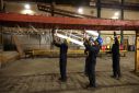 Workers remove pieces of wire from a frame inside the factory of Corbetts The Galvanizers in Telford