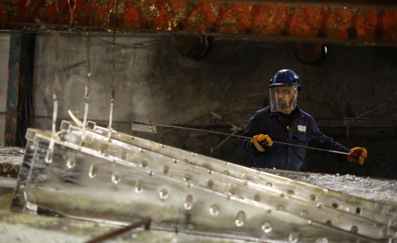 Worker removes pieces of metal from the galvanising bath inside the factory of Corbetts The Galvanizers in Telford