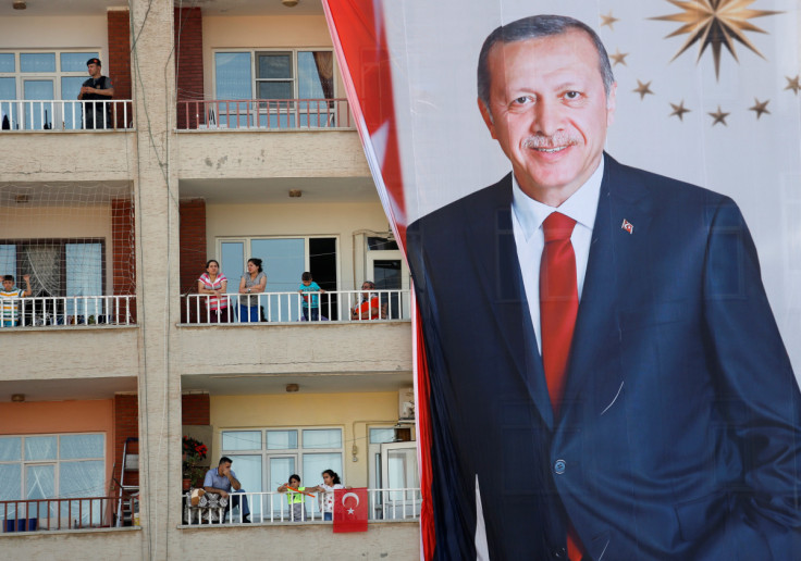 People watch an election rally of Turkish President Tayyip Erdogan from a building in Mardin