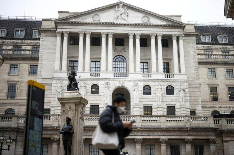 A person walks past the Bank of England in the City of London financial district in London
