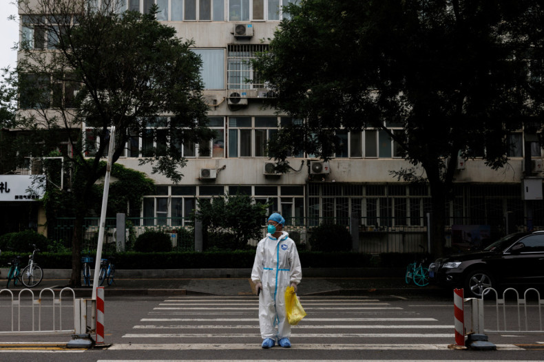 Medical worker in a protective suit crosses a street following a coronavirus disease (COVID-19) outbreak in Beijing