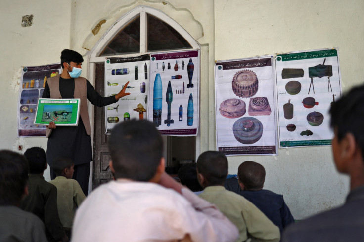 Massoud, an Afghan teacher, teaches children about the explosive ordinance risk in Qafas Kalay village in Kabul
