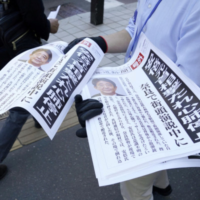 Copies of an extra edition of a newspaper is handed out to pedestrians in Sapporo, after former Japanese Prime Minister Shinzo Abe was shot, in Sapporo