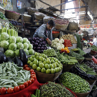 A vegetable seller waits for customers at a market in Ahmedabad