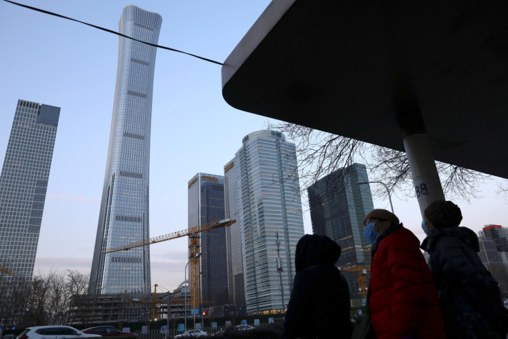 People wait at a bus stop in Beijing’s Central Business District (CBD)