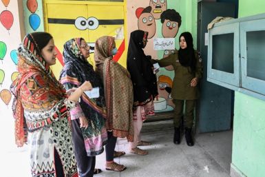 Women line up to cast their ballots in the Punjab province assembly by-election