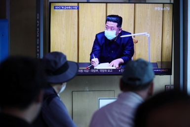 People watch a news report on the coronavirus disease (COVID-19) outbreak in North Korea