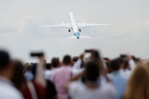 Attendees watch a Boeing 777X aircraft during a display at the Farnborough International Airshow, in Farnborough