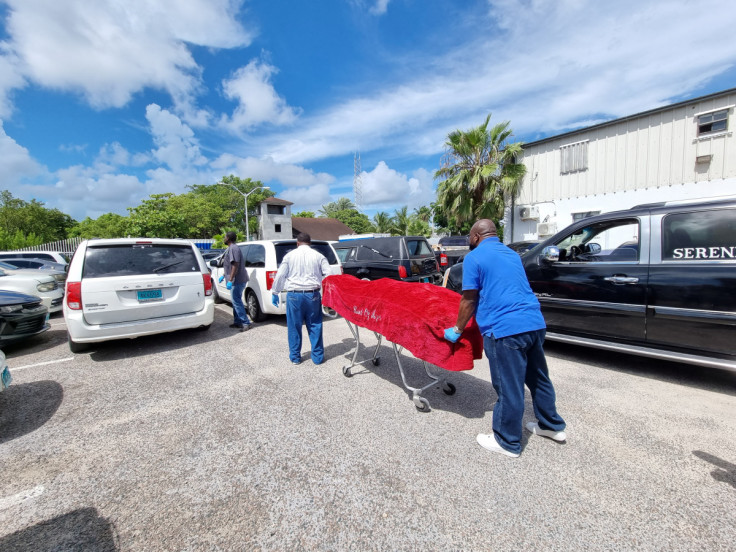 The body of a migrant who died after their vessel capsized off the coast of The Bahamas is taken away by mortuary workers in Nassau