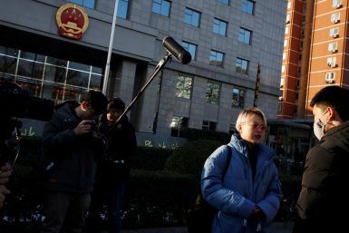 Teresa Xu talks to a supporter outside Chaoyang People's Court before a court hearing in Beijing