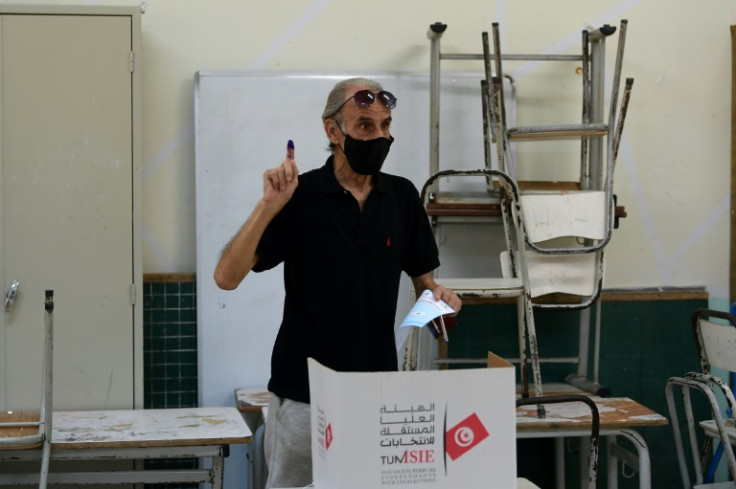 A man holds up his index figure, daubed with ink, to show that he has voted in the referendum