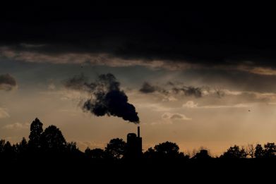 Smoke rises above a factory at sunset in Rugby