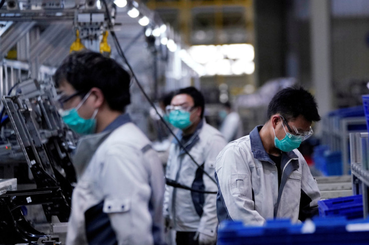 Employees wearing face masks work on a car seat assembly line at Yanfeng Adient factory in Shanghai