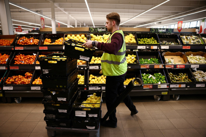A employee arranges produce inside a Sainsbury’s supermarket in Richmond, west London