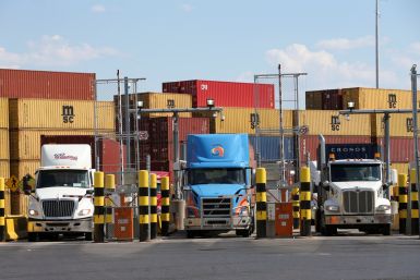 Trucks loaded with shipping containers leave the Port of Montreal