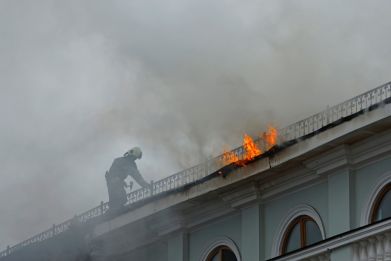 Firefighters extinguish a fire on the roof of a railway station in Donetsk