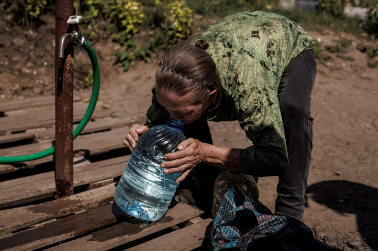 A local resident drinks clean water from a canister she just filled up, as Russia's attack on Ukraine continues, in Sloviansk