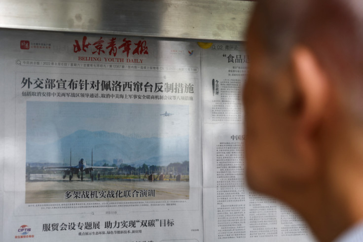 A man reads a newspaper report with an image of military exercises near Taiwan by the Chinese People's Liberation Army's (PLA) Eastern Theatre Command on the front-page, at a newspaper stand in Beijing