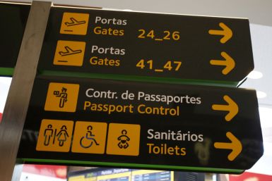 Gates, passport control and toilets signs are seen at Lisbon's airport