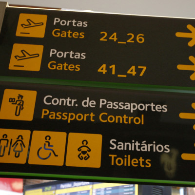 Gates, passport control and toilets signs are seen at Lisbon's airport