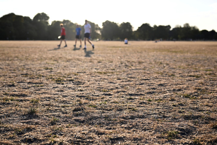 People walk as the sun sets on Clapham Common in London