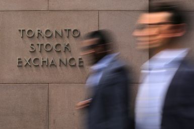 Businessmen pass the Toronto Stock Exchange sing in Toronto