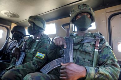 Soldiers from the Rwandan security forces sit inside an APC near the Afungi natural gas site