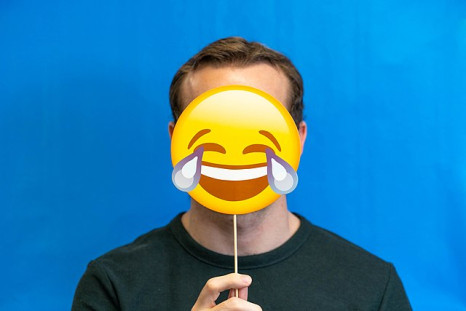 Man holding a laughing emoji mask
