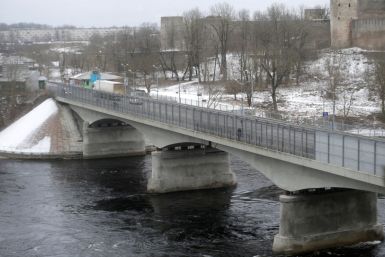 People walk on the bridge over Narva river at the border crossing point with Russia in Narva