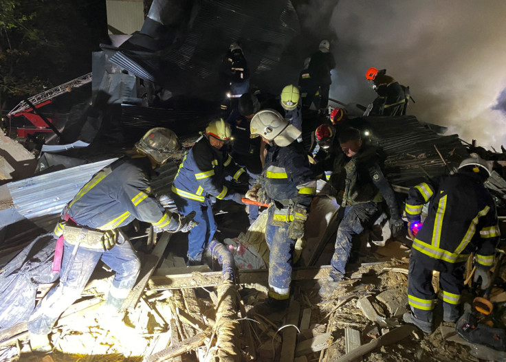 Rescuers carry a person released from debris of a residential building destroyed by a Russian missile strike