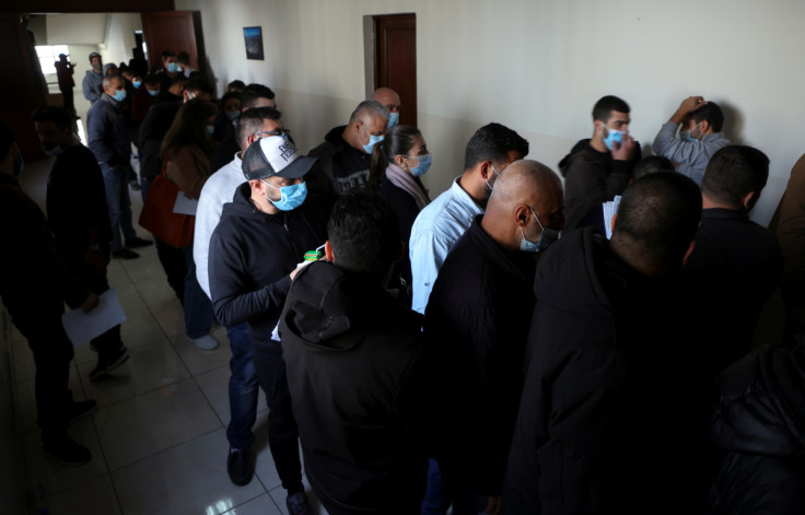 People queue at a vehicle licensing agency in Dekwaneh