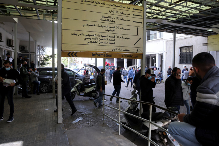 People wait at a vehicle licensing agency in Dekwaneh