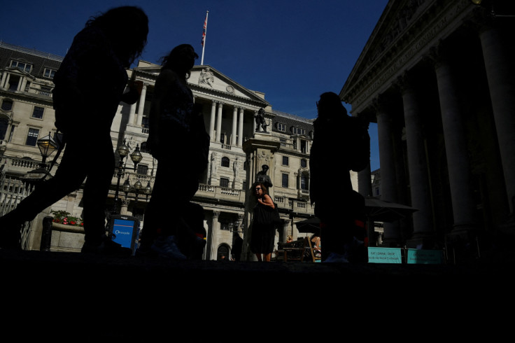 Pedestrians walk past the Bank of England, in London