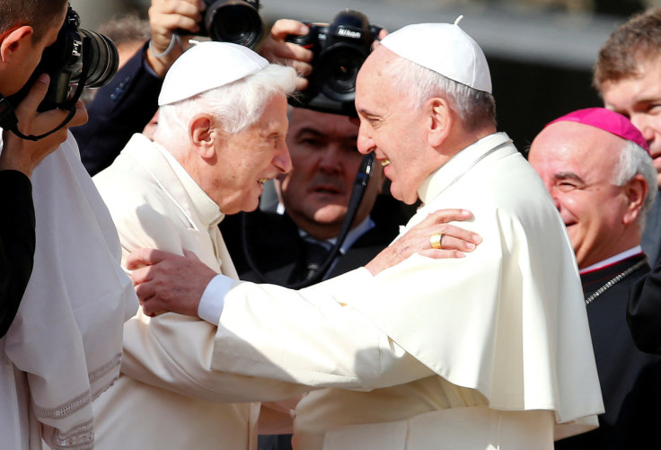 Pope Francis greets Emeritus Pope Benedict XVI before a mass in Saint Peter's square at the Vatican