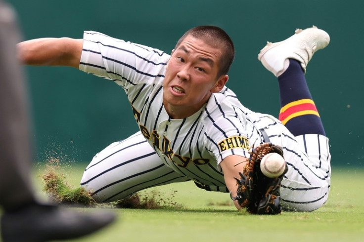 Outfielder Ryunosuke Nagata dives for a fly ball during the annual high school baseball tournament known as Koshien