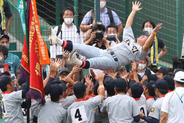 Players from Sendai Ikuei, a school in Miyagi prefecture, toss their coach into the air after winning the two-week All-Japan High School Baseball Championship Tournament
