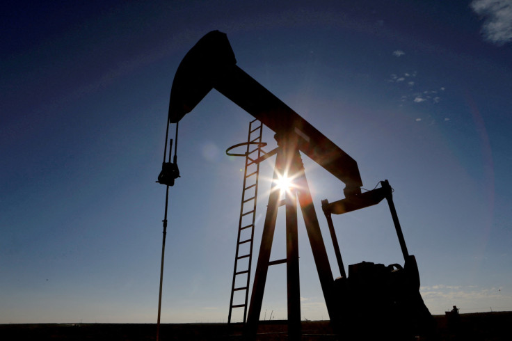 The sun is seen behind a crude oil pump jack in the Permian Basin in Loving County